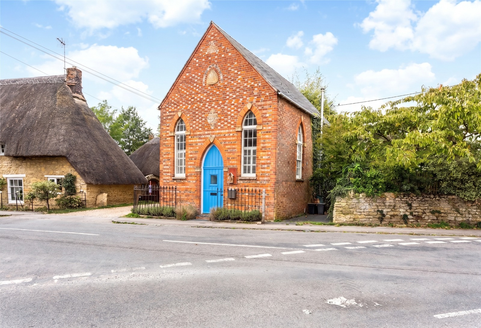 The Green Chapel: red brick chapel with a bright blue arched door in Standlake